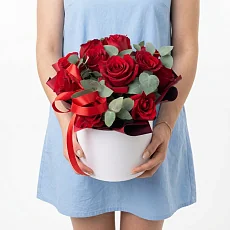 Красные розы в шляпной коробке и зелень