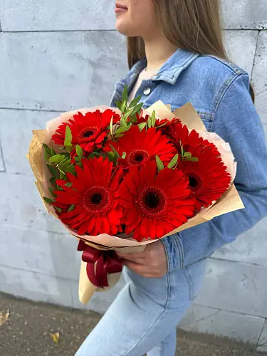 На фото №3 Букет живых цветов из 7 Красных гербер с зеленью в дизайнерской упаковке