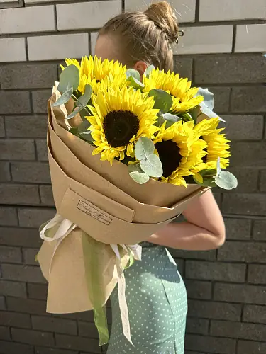 На фото №4 Букет живых цветов из 5 Подсолнухов в дизайнерской крафтовой бумаге