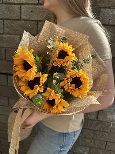 На фото №4 Букет живых цветов из 5 подсолнухов оформленный в дизайнерскую упаковку